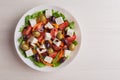 Traditional Greek salad arugula, lettuce, tomatoes, feta cheese, cucumbers, black olives, balsamic sauce on white plate on Royalty Free Stock Photo