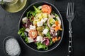 Traditional greek salad with fresh vegetables, feta and olives, on black background, top view flat lay Royalty Free Stock Photo