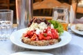 A traditional Greek salad of healthy vegetables including tomatoes, olives and lettuce, with feta cheese served at an outdoor cafe Royalty Free Stock Photo