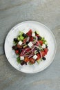 Traditional Greek salad on marble plate, stone background