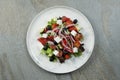 Traditional Greek salad on marble plate, stone background