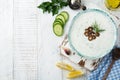 Traditional Greek sauce Tzatziki. Yogurt, cucumber, dill, garlic and salt oil in a ceramic bowl on a light wooden background. Royalty Free Stock Photo