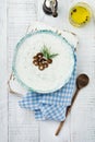 Traditional Greek sauce Tzatziki. Yogurt, cucumber, dill, garlic and salt oil in a ceramic bowl on a light wooden background. Royalty Free Stock Photo