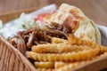 Traditional Greek souvlaki meat and pita served with white tzatziki sauce and French fries in recyclable paper plate for take away Royalty Free Stock Photo