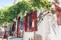 Traditional greek tavern on Amorgos island, Greece. Beautiful street with flowers and cafe tables Royalty Free Stock Photo