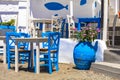 Traditional Greek tavern in the beach side with typical blue chairs. Astypalea island, Greece