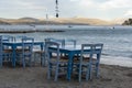 Traditional greek tavern with wooden tables on sandy beach near water waiting for tourists in Tolo, Peloponnese, Greece