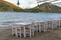 Traditional greek tavern with wooden tables on sandy beach near water waiting for tourists in Tolo, Peloponnese, Greece Royalty Free Stock Photo