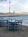 Traditional greek tavern with wooden tables on sandy beach near water waiting for tourists in Tolo, Peloponnese, Greece Royalty Free Stock Photo