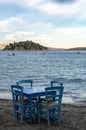 Traditional greek tavern with wooden tables on sandy beach near water waiting for tourists in Tolo, Peloponnese, Greece Royalty Free Stock Photo