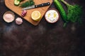 Traditional greek tzatziki sauce with ingredients on dark rustic background. Greek yogurt with cucumber, dill, garlic and lemon.