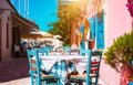 Traditional greek vivid colored tavern on the narrow Mediterranean street on hot summer day Royalty Free Stock Photo