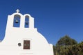 Traditional Greek white church arch with cross and bells in village Oia of Cyclades Island Santorini Greece Royalty Free Stock Photo