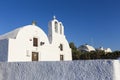 Traditional Greek white church arch with cross and bells in village Oia of Cyclades Island Santorini Greece Royalty Free Stock Photo