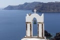 Traditional Greek white church arch with cross and bells in village Oia of Cyclades Island Santorini Greece Royalty Free Stock Photo