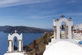 Traditional Greek white church arch with cross and bells in village Oia of Cyclades Island Santorini Greece Royalty Free Stock Photo