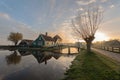 Traditional green dutch house with little wooden bridge against blue sky in the Zaanse Schans village Royalty Free Stock Photo