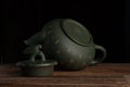 Green traditional chinese Yixin clay teapot with cicada on the cover. On the wooden table and black backround Royalty Free Stock Photo
