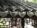 Traditional grey Chinese roof tiles with red metal lattice beneath. Shanghai, China. Royalty Free Stock Photo