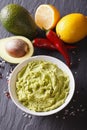 Traditional guacamole sauce with ingredients close-up. vertical