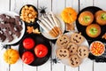 Traditional Halloween treat table scene over a white wood background