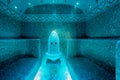 Traditional hammam sauna with modern colored lighting and stone washbasin