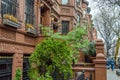 Traditional Harlem Neigborhood in New York City. Similar Style Brownstone Houses in a Row and People Walking on Pavement Royalty Free Stock Photo