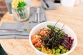 Traditional Hawaiian dish poke bowl with fork. Hawaiian salmon fish with rice, radish,cucumber, tomato, sesame seeds and Royalty Free Stock Photo