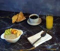 Traditional healthy breakfast, oatmeal with fruits, a cup of black coffee, two croissants and a glass of orange juice. Close-up Royalty Free Stock Photo