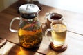 Traditional heral tea with glass teapot, cup, dried rose buds. Flowers on wooden table at home,sunlight background
