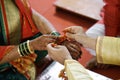 Traditional Hindu marriage ceremony where groom tides holy thread on the wrist of bride