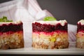 Portion of Layered fish salad Herring under fur coat served in culinary rings.