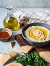 Traditional Homemade chick pea hummus in a bowl, drizzled with olive oil and dry paprika spice on wood cutting board Royalty Free Stock Photo