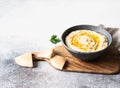 Traditional Homemade chick pea hummus in bowl, drizzled with olive oil and dry paprika spice on wood cutting board Royalty Free Stock Photo