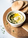 Traditional Homemade chick pea hummus, drizzled with olive oil and fresh parsley and fresh pita slices on wood cutting board Royalty Free Stock Photo