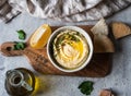 Traditional Homemade chick pea hummus, drizzled with olive oil and fresh parsley and fresh pita slices on wood cutting board on Royalty Free Stock Photo