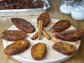 Traditional homemade and Delicious Spanish Torrijas making a circle and three cinnamon sticks in the middle on a round wooden