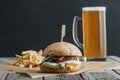 traditional homemade hamburger, french fries and glass of beer on baking paper Royalty Free Stock Photo