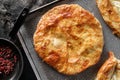 Traditional homemade Romanian and Moldovan round bread, served on a plate, dark background. Bakery products