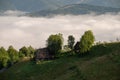 Traditional homes in Transylvania , sunrise with mist in the mountains , Romania