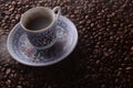 traditional hot coffee cup with beans and smoke steam over a black background. Royalty Free Stock Photo