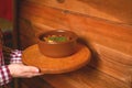 Traditional hot goulash soup. Waiter serving vegetable stew in a pot. Concept for a tasty meal. Restaurant service. Royalty Free Stock Photo