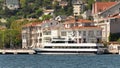 Traditional houses of Bosphorus strait, Istanbul, Turkey, and docked yacht, with background of green mountains