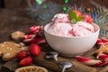 Traditional ice cream served in a glass bowl. Displayed with candy canes on wooden rustic table. Sparkling Christmas tree lights b