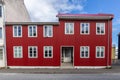 Traditional Icelandic ironclad red residential house with white window frames, clad in corrugated metal sheets in Reykjavik,