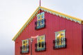 Traditional Icelandic red ironclad building with colorful windows and roof, Reykjavik,