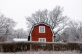 Traditional idyllic Swedish red wooden timber cabin house paint with falu red paint in winter landscape