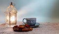 Traditional Iftar setting for breaking the fast during Ramadan with a glowing fanous lantern, sweet dates, and a warm cup of Royalty Free Stock Photo