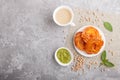 Traditional indian candy jalebi in white plate with mint chutney on a gray concrete background. top view