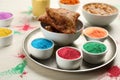 Traditional Indian food and color powders on white wooden table, closeup. Holi festival celebration Royalty Free Stock Photo